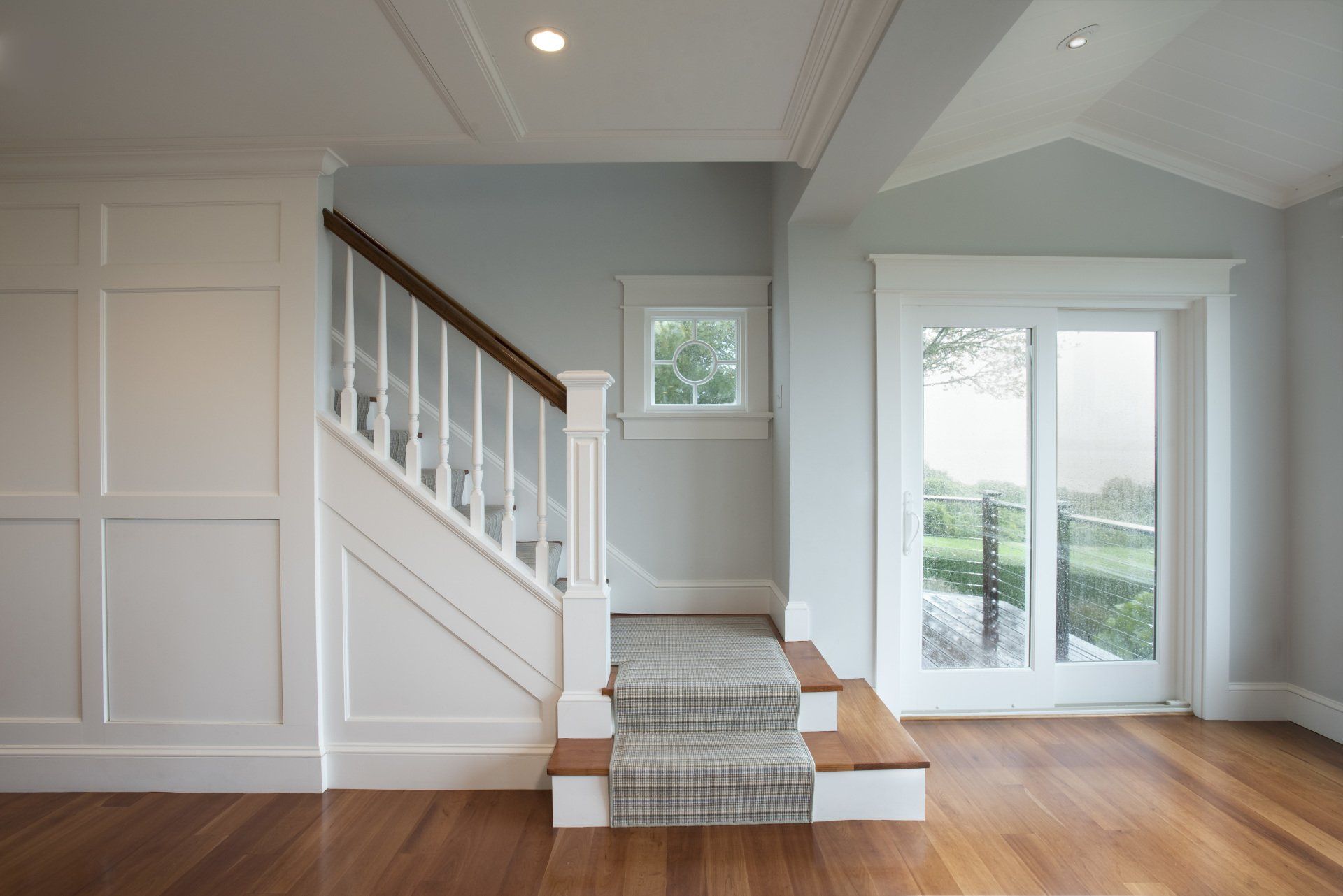 An empty room with a staircase and a window.