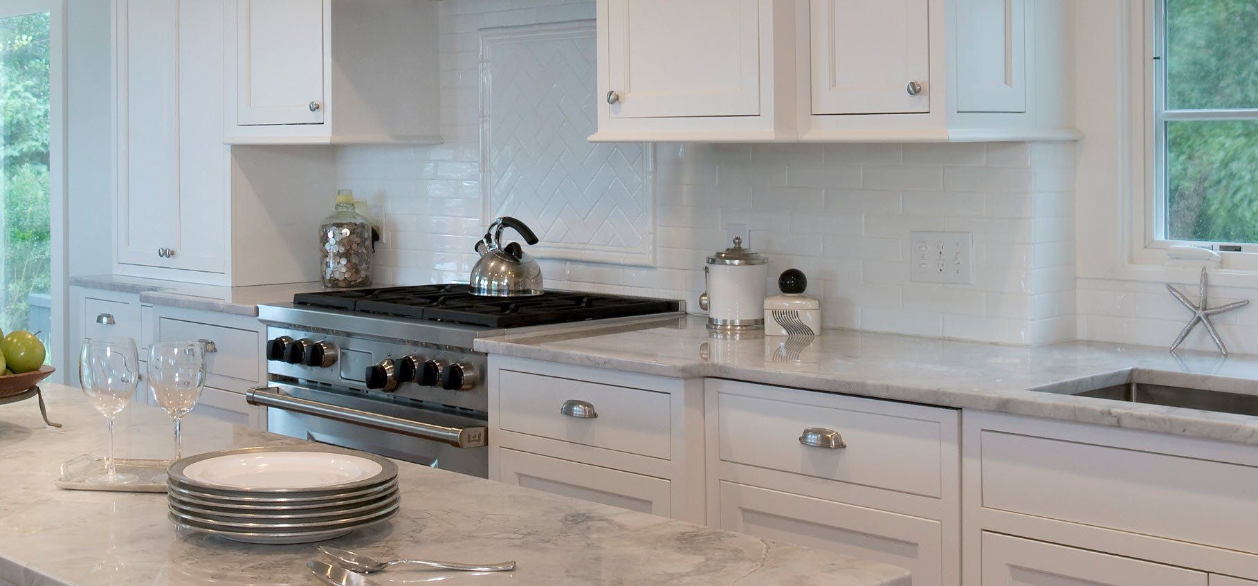 A kitchen with white cabinets and stainless steel appliances