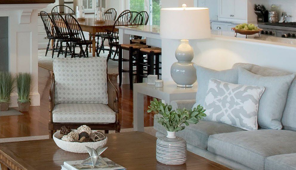 A living room with a couch , chair , table and lamp.