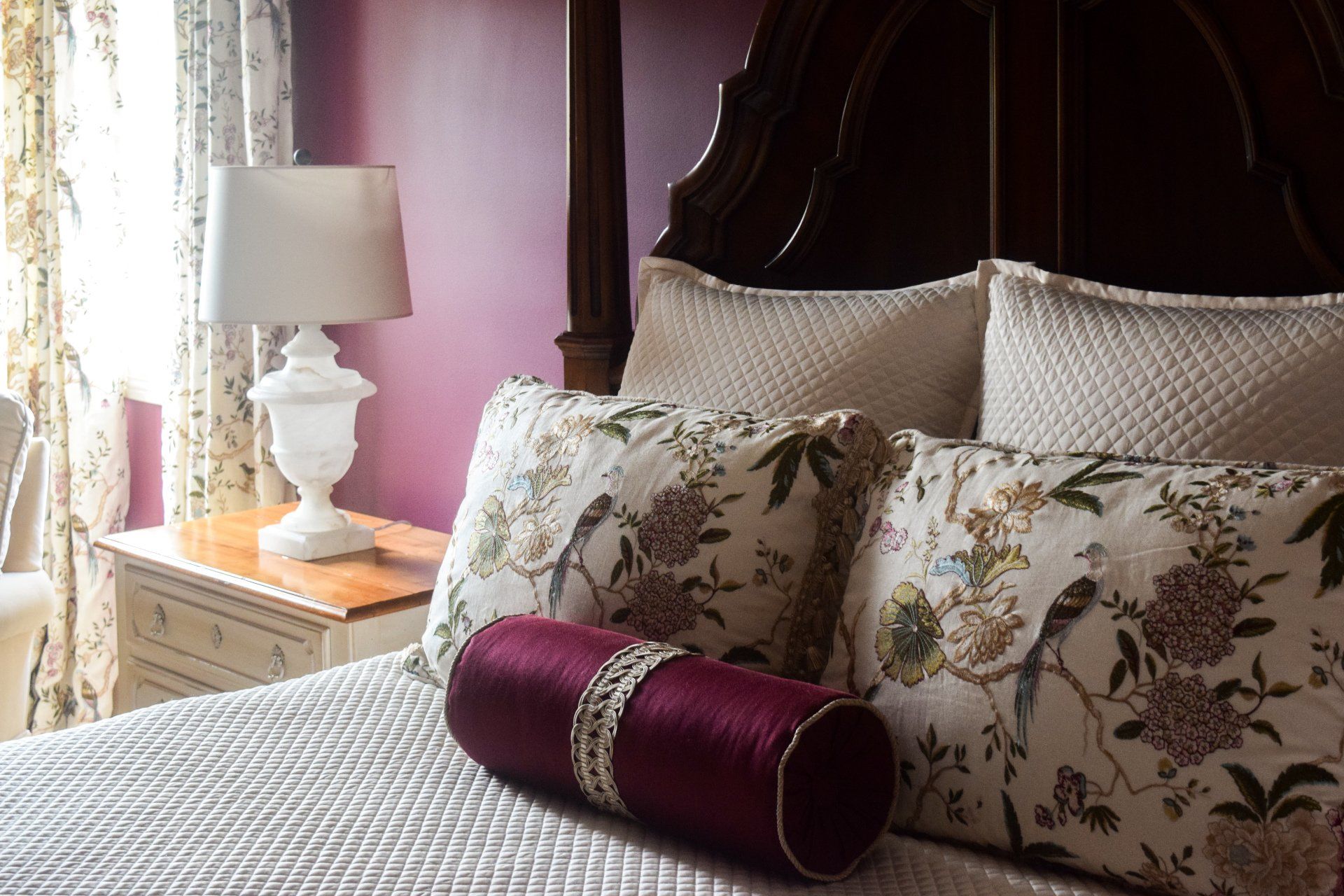 A bed with pillows and a lamp in a bedroom