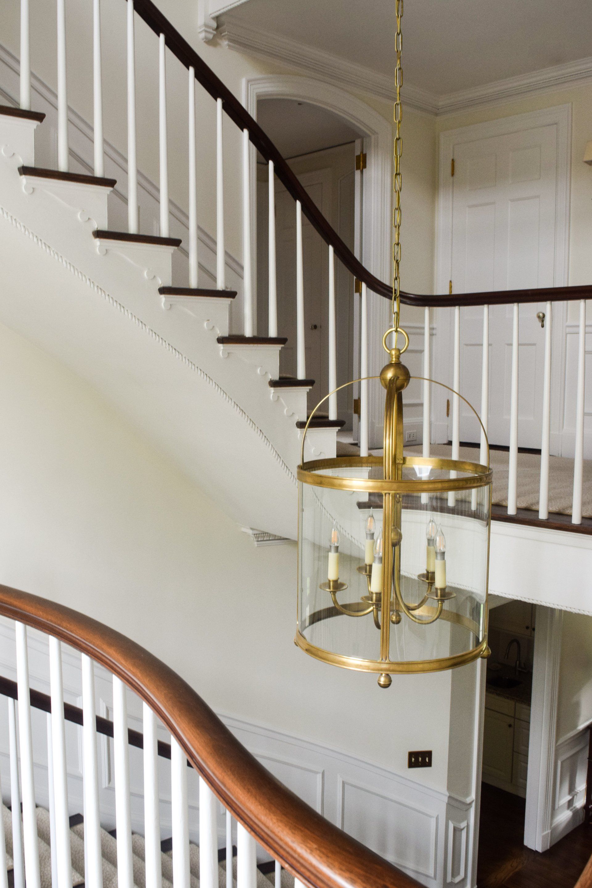 A staircase with a brass chandelier hanging from it