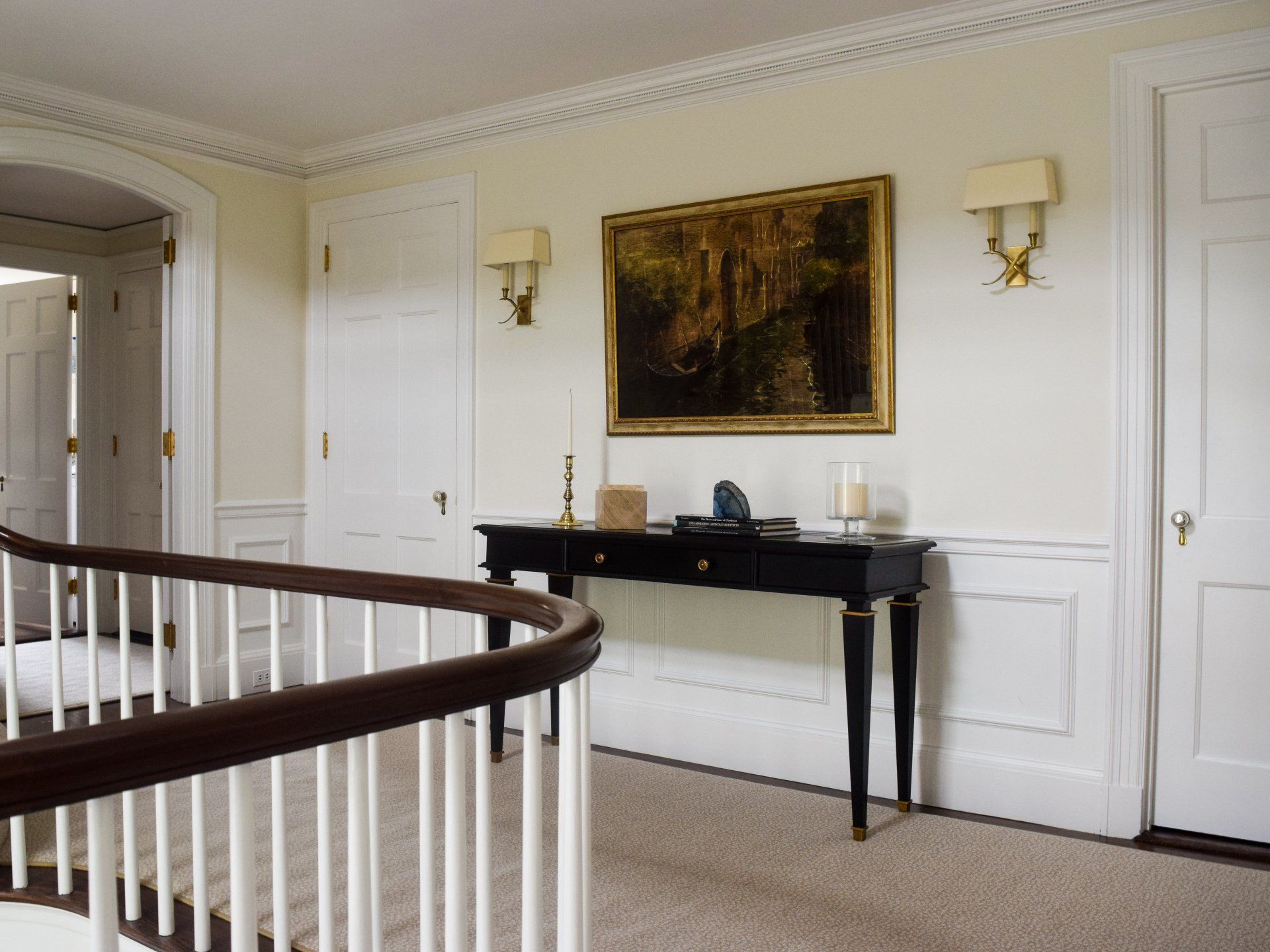 A hallway with a table and a picture on the wall