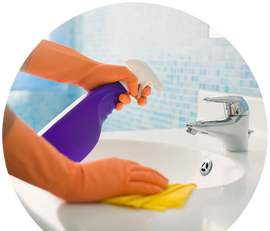a person wearing orange gloves is cleaning a bathroom sink