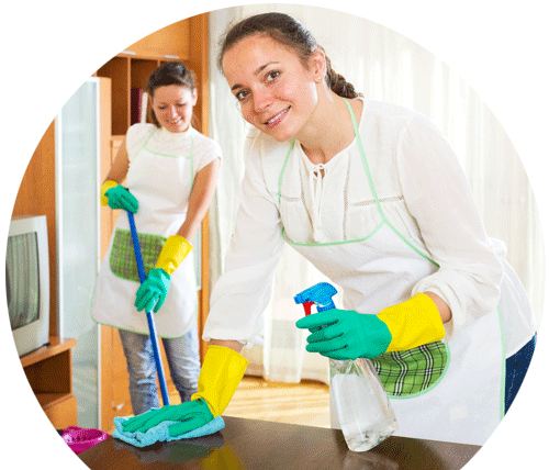 two women are cleaning a table in a living room .