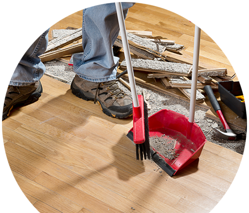 a person is cleaning a wooden floor with a broom and shovel .