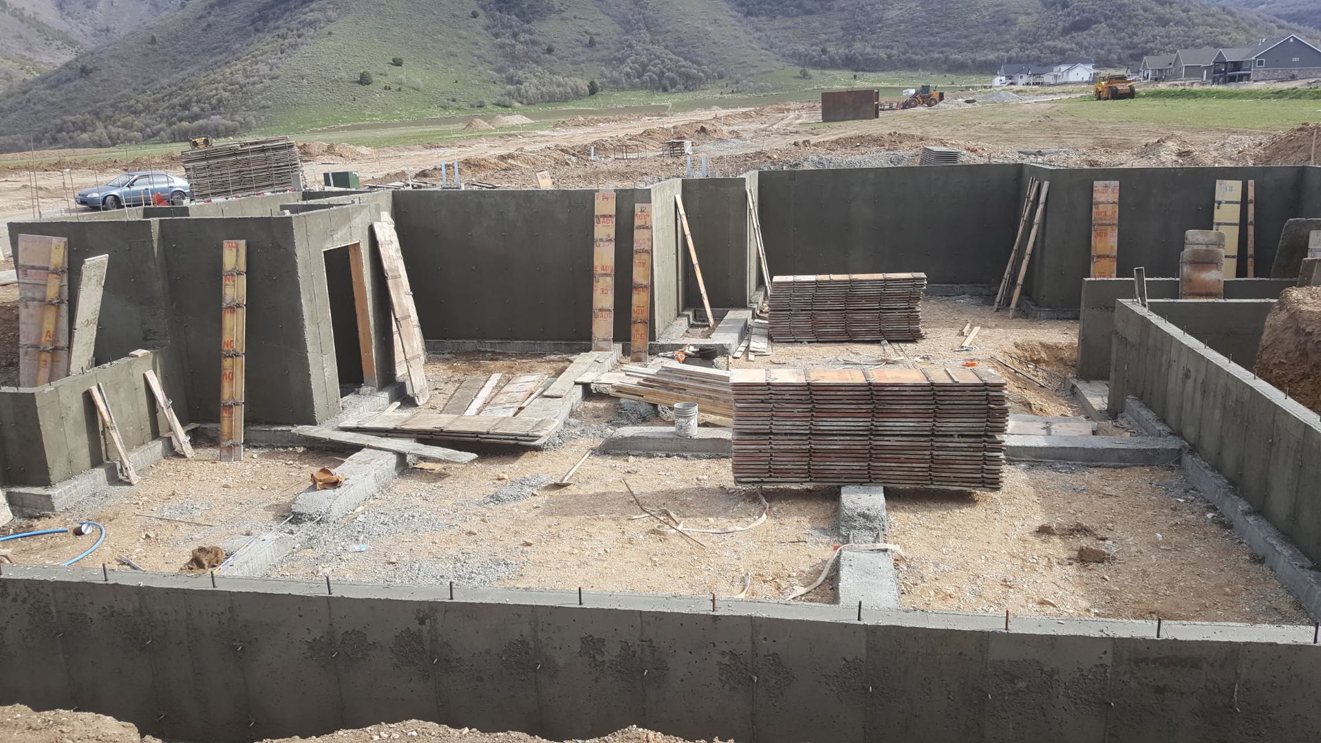 Partially built concrete structure with stacked bricks and mountains in the background