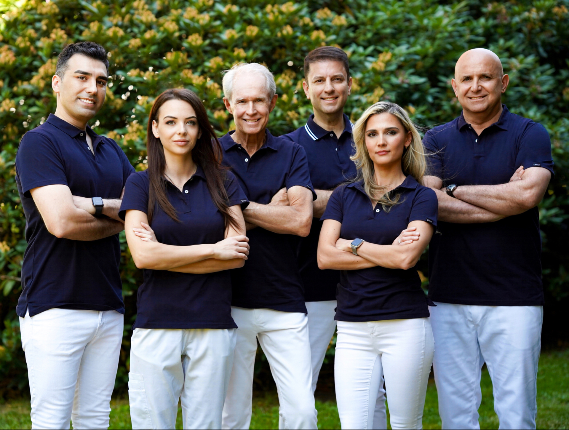 En gruppe mennesker som står ved siden av hverandre med armene i kors.