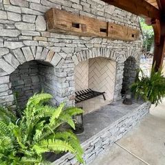 A stone fireplace with a television on top of it