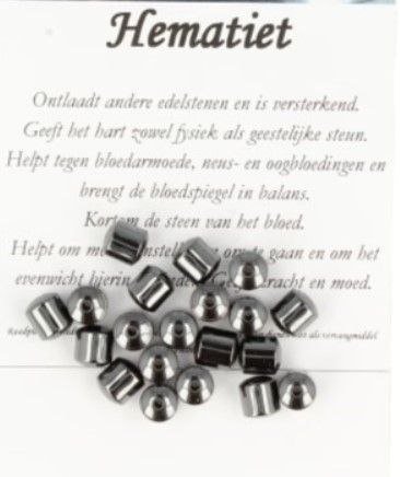 Grijze metalen kralen en kegels verspreid over een witte ondergrond.