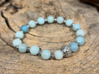 Ketting met lichtblauwe kralen op een kaartje. Tekst: