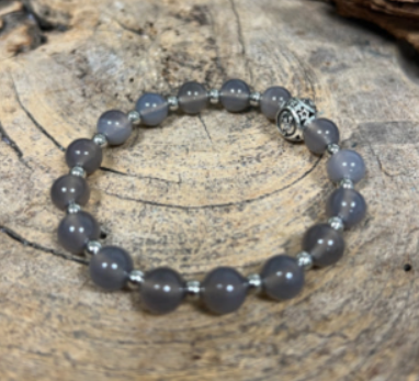 Armband met grijze kralen en een schorpioen-sterrenbeeldkaart. Illustratie donkergrijze schorpioen op een gouden achtergrond.