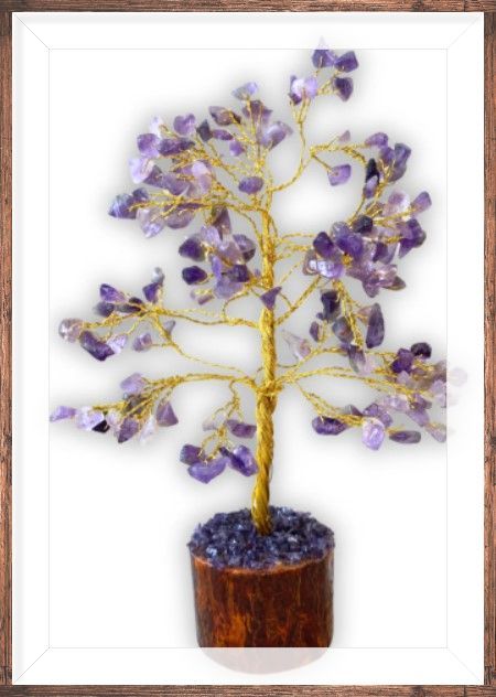 Amethistkristalboom met goudkleurige draadtakken in een houten pot, met daartussen bloemen en drijfhout.