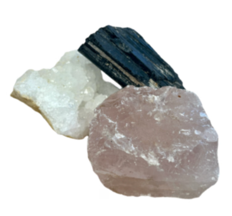 Ruwe rozenkwarts, witte kwarts en zwarte toermalijnkristallen op hout met bloemen.