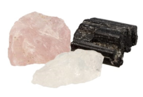 Zwarte doos met drie stenen: roze, grijs en zwart, op zwart satijn.