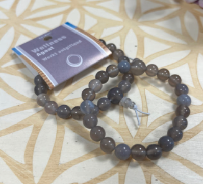 Armband van donkerblauwe en grijze kralen met kwastje.