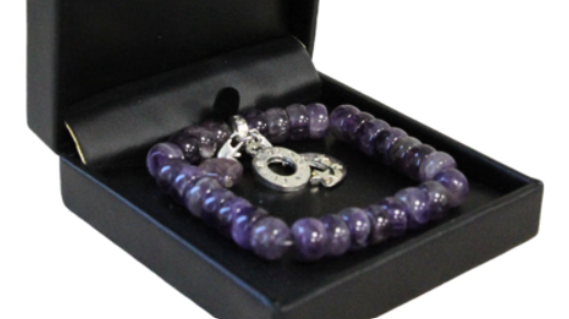 Amethist armband in een zwart doosje met een zilveren bedel.