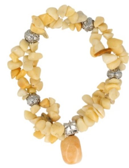 Armband van barnsteen met kralen en een hanger, afgebeeld op drijfhout.