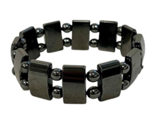 Hematiet armband op een houten ondergrond. Donkergrijze rechthoekige en ronde kralen.