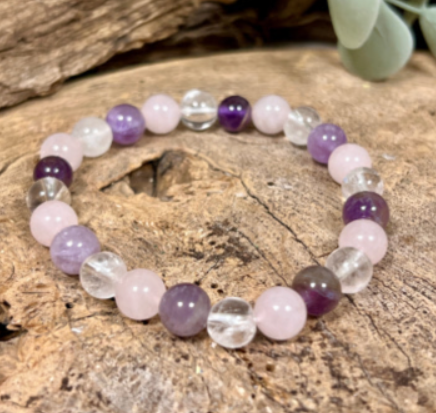 Rekbare armband met kralen, paarse, roze en heldere edelstenen.