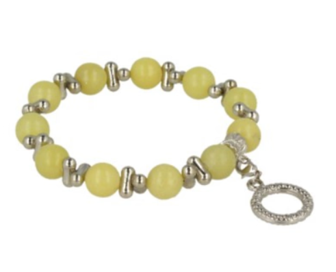 Armband van gele kralen met zilveren accenten, rustend op een gepatroneerde steen.