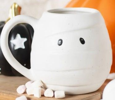 Mok met mummie-thema, met zwarte ogen voor twee brandende pompoenen.