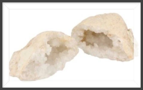 Twee halve geode stenen met witte kristallen erin.
