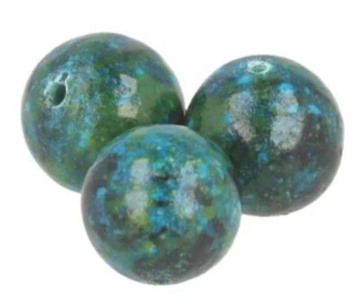 Drie blauwgroene bollen op een wit, rond, gestructureerd oppervlak.