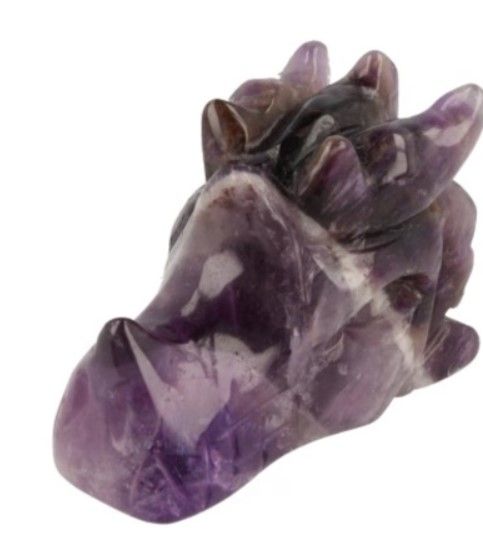 Twee amethist drakensculpturen met roze bloemen op een houten oppervlak.