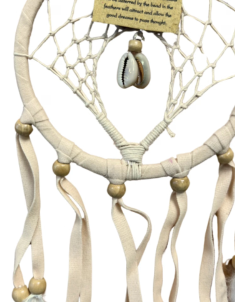 Crèmekleurige dromenvanger met witte veren, hangend op een houten achtergrond.