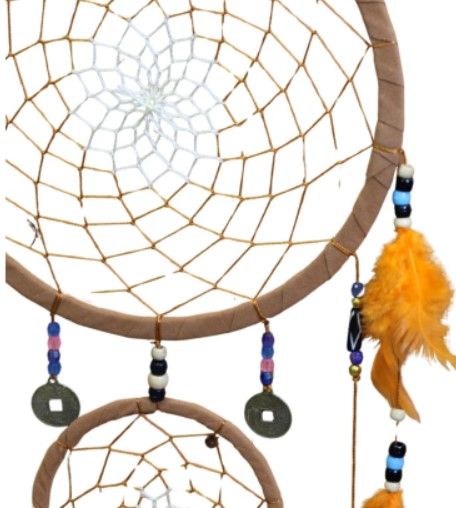 Dromenvanger met bruine cirkels, oranje veren en kralen, hangend tegen een witte muur.