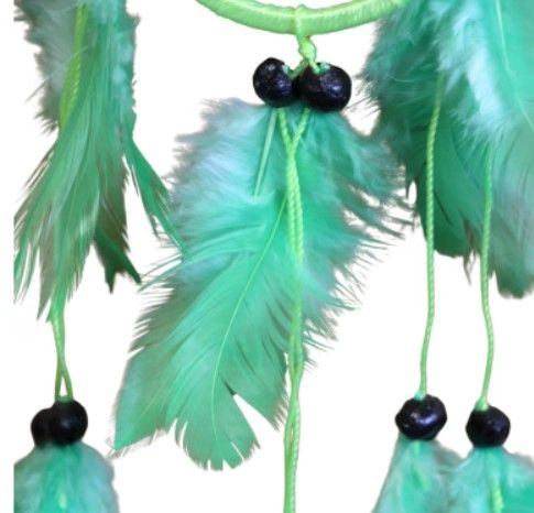 Groene dromenvanger met veren en zwarte kralen.