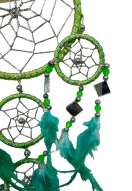 Groene dromenvanger met turquoise veren en hangende kristallen.