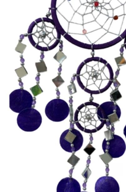 Paarse dromenvanger met meerdere cirkels en hangende kralen.