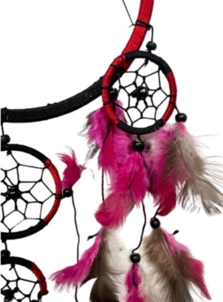 Dromenvanger met zwart bandje, rode en zwarte ringen en roze en bruine veren.