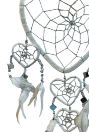 Witte dromenvanger in de vorm van een hart, met kleinere hartjes, kralen en veren eronder.