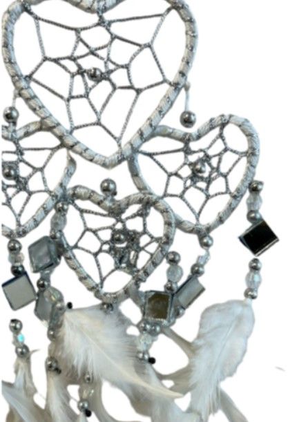 Witte dromenvanger in de vorm van een hart, met veren en hangende kralen.