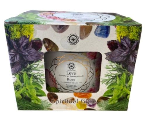 Een kaars in een blauw getint glazen potje met rozenkwartskristallen en een deksel met de tekst 