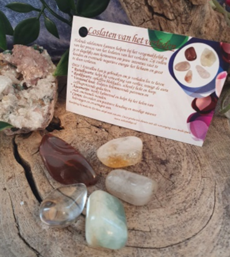 Zes gepolijste edelstenen gerangschikt in de vorm van een bloem: helder, bruin, roodbruin, zeegroen en lichtgeel.