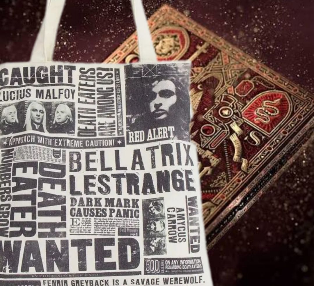 Een draagtas met opsporingsposters van Dooddoeners naast een sierlijk, rood gebonden boek.