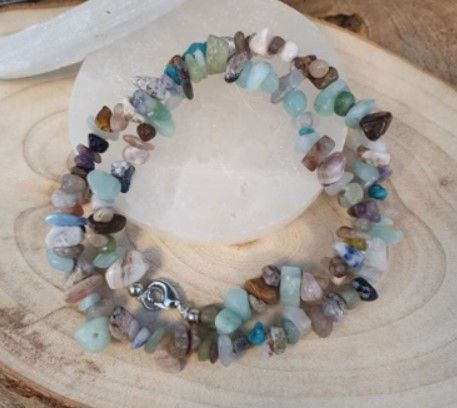 Ketting gemaakt van verschillende, onregelmatig gevormde kleurrijke stenen en een zilveren sluiting.