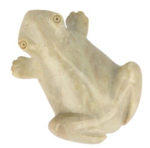 Gesneden stenen kikkersculptuur op hout, naast een kwartskristal en een stuk drijfhout.