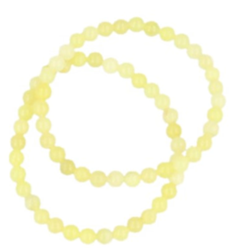 Twee lichtgroene kralenarmbanden op een gevlekt bruin oppervlak.