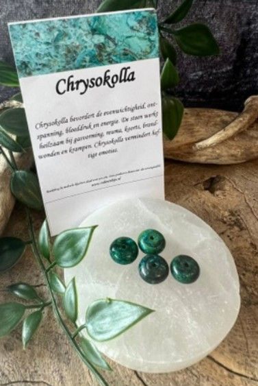 Vier ronde, platte, groen-blauwe kralen met een gat in het midden, op een witte achtergrond.