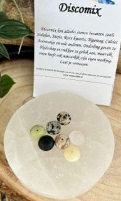 Zeven ronde, platte edelsteenparels in verschillende kleuren, elk met een gat in het midden.