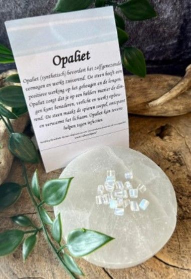 Vierkante, witte opaalglazen kralen verspreid op een witte achtergrond.