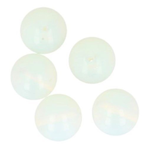 Vijf opalietbollen op een schaal van witte seleniet, met een pakje met het label