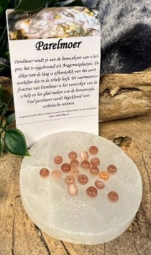 Perzikkleurige ronde kralen met gaatjes, verspreid.