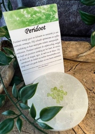 Lichtgroene, donutvormige kralen met gaatjes in het midden, verspreid over een wit oppervlak.