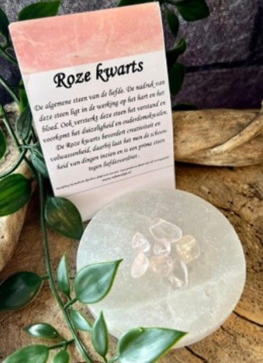 Zeven getrommelde, doorschijnende rozenkwartsstenen, lichtroze van kleur, tegen een witte achtergrond.