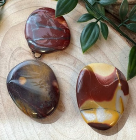 Twee gepolijste stenen, gevlekt in de kleuren rood, geel, bruin en crème.